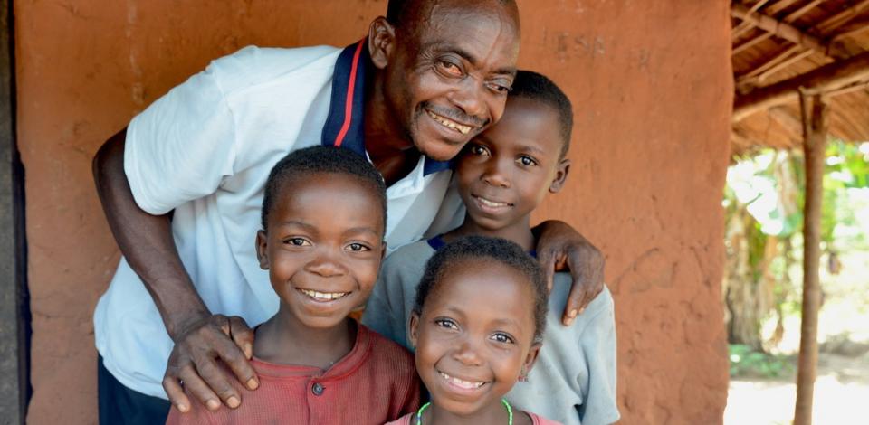 Vincent together with three of his children: Joseph (10, dark-red shirt), Mado (12, bright shirt) and Elysee (6, in front).Vincent (50) lost the eyesight of his left eye due to onchcerciasis - but Mectizan® saved the vision of his right eye.