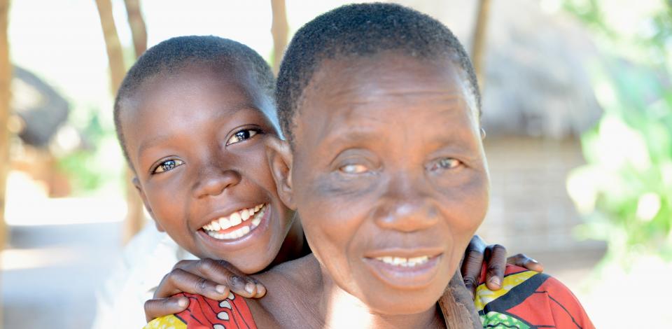Berthine (64) is blind due to onchocerciasis. Here with her grandchild Jean (8).