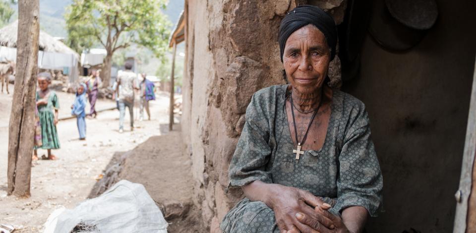 Anguach has trichiasis stage trachoma but is afraid to get free surgery in Gazgibla, Amhara Region, Ethiopia, on May 18, 2017. "My daughter had the trachoma trichiasis surgery. But I live by myself, if I have a bandage on my eye I can't go gather wood and water." She uses eye drops to help with the pain of the trachoma. A CBM-supported health extension worker, Asefash Mekonnen Sefiw, is encouraging her to accept the free surgery despite her fears.
